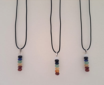 Three chakra beaded necklaces hanging against a white background.